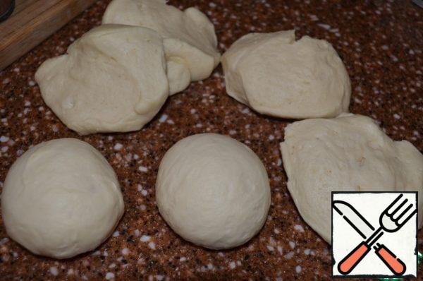 Punch down the risen dough, divide into 6 parts for 125 g..
Roll up in koloboks, cover and let rest for 10 minutes.