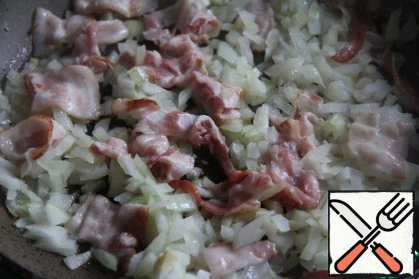 In a saucepan, fry the onion and bacon in oil until golden brown.
