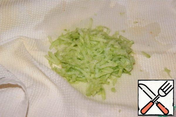 Peel the cucumber and grate it on a coarse grater.
Add a pinch of salt and 1 tablespoon of vinegar, mix.
Wrap everything in a kitchen towel and mix...
