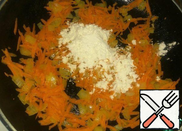 Cut the onion into cubes, grate the carrots on a coarse grater.
Fry onions in vegetable oil until transparent, add carrots. Fry the carrots until soft. Add 1 tbsp flour, mix.
