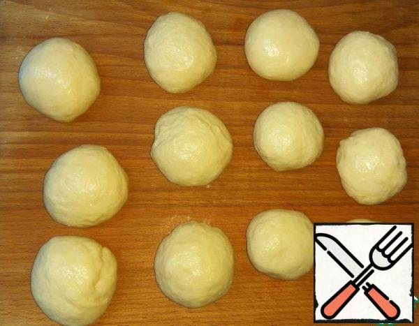 Punch down the risen dough, divide into 12 pieces and roll into balls. If the dough will still stick to your hands, then do not use flour. In this case, to grease the hands of vegetable oil.