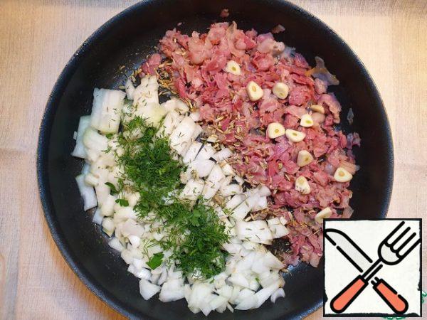 In the pan to the fried bacon, add the onion, garlic, fennel seeds, salt and pepper, herbs.