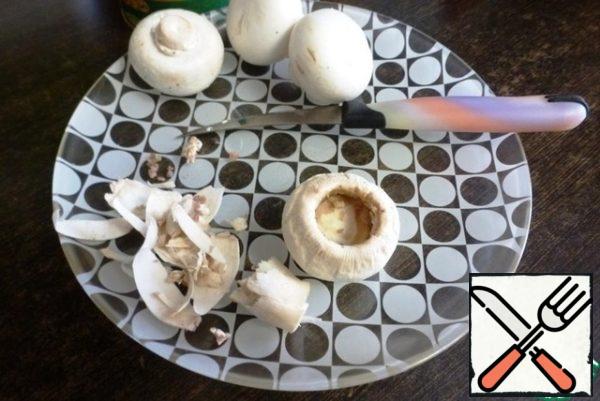 From the mushroom caps, remove the upper skin. It is removed easily, it is only necessary to pick up a knife edge. Unscrew the leg, a teaspoon to choose the remains to get a bowl.