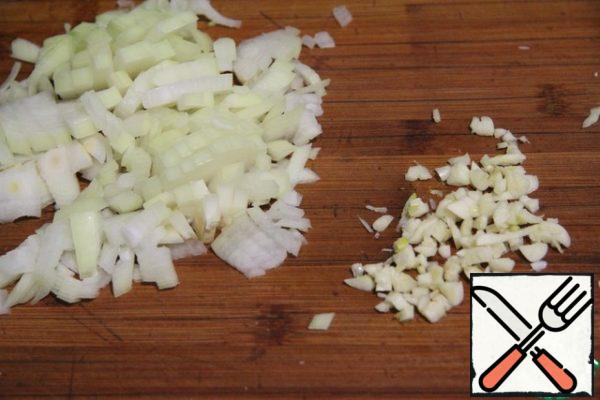Peel the onion, finely chop and fry with garlic in vegetable oil until soft.
