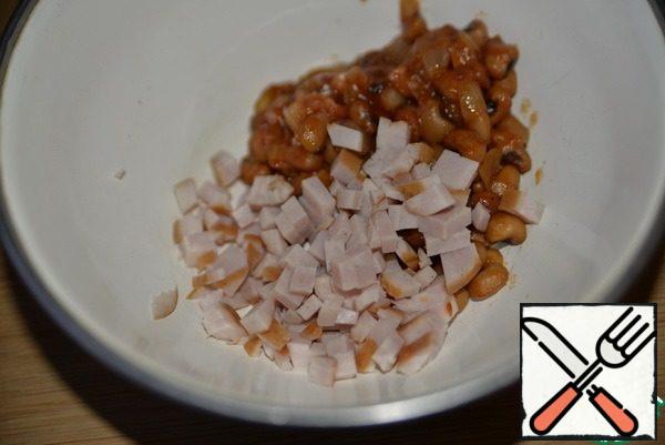 We take ham, I have chicken or boiled chicken fillet, cut into small cubes and put it to the beans.
