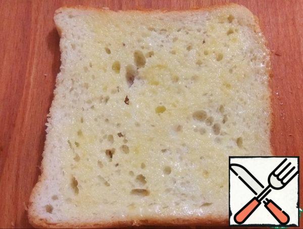 Melt the butter, brush the slices of bread on one side.