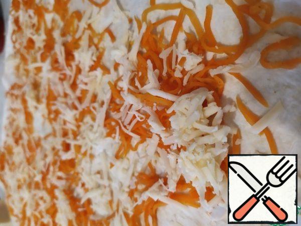Put the second sheet of pita bread, spread the carrots on top in Korean (after squeezing it well) and grated cheese.
Turn into a roll and put in the refrigerator until the desired hour.