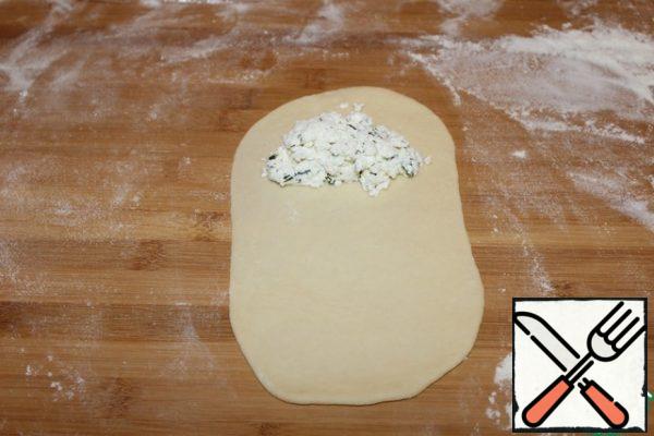Roll out each piece of dough into an oval. Distribute the filling.
