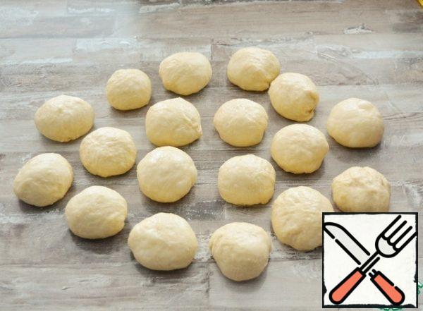 Put the dough on a greased surface, knead well. Divide into pieces of about 50 grams each, form balls from them and leave for 10-15 minutes, covered with a film.
