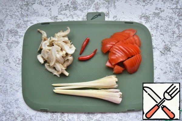 Crush lemongrass and cut into segments of 4-5 cm With lime to remove the zest and squeeze the juice. Cut tomatoes into slices, mushrooms into strips. Cut the chili pepper in half lengthwise and remove the seeds, cut the galangal root into slices.