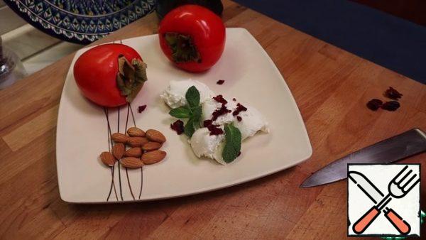 Finely chop the dried cranberries and decorate our tender cottage cheese with them. Add mint leaves to the decor.
