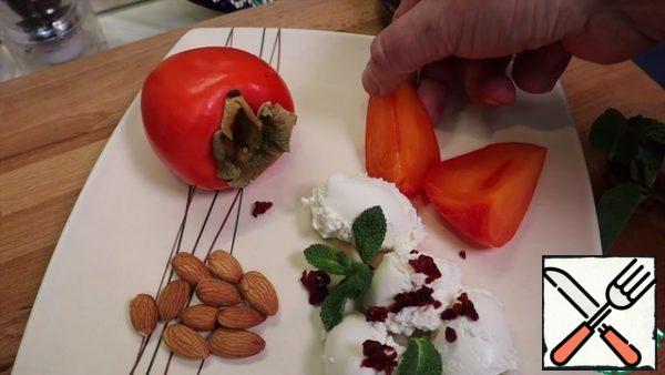 Slice the persimmons coarsely and place next to the curd cheese on a plate.