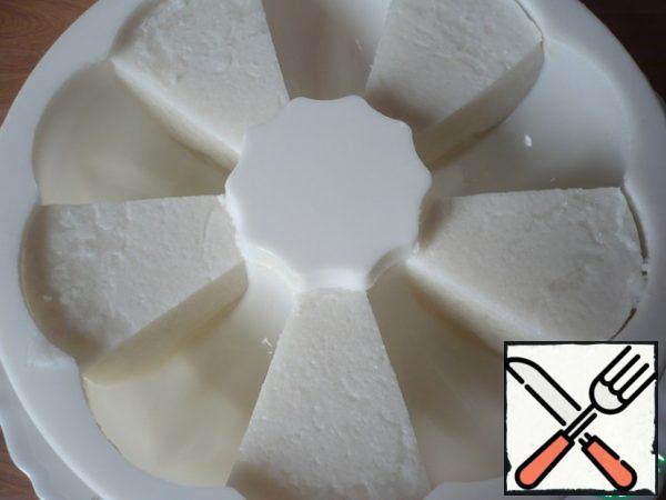 Take the cut slices of coconut jelly and again spread in the form, through one cell.
