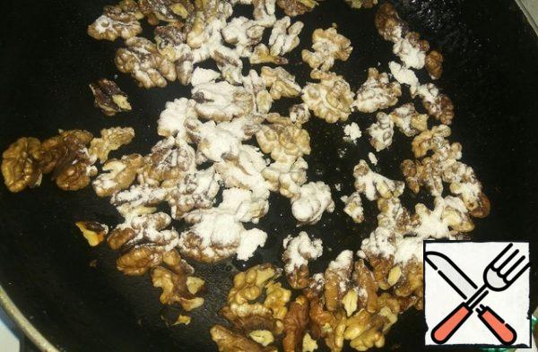 For the filling, dry the nuts in a pan, stirring them.
It is necessary to add powdered sugar, each time adding, when the powder begins to melt.