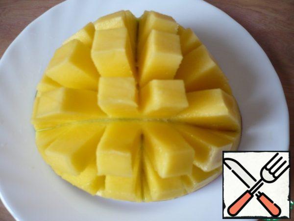 Prepare fruit: mango cut into small squares.