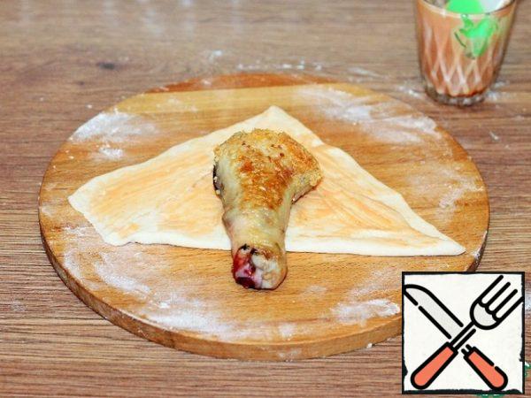 Mix tomato ketchup (2 tbsp. l., tastier spicy) with sour cream (2 tbsp. l.) and a pinch of salt.
Form 6 handkerchiefs from the dough, one tip is longer than the other. Brush with sour cream mixture and put the stuffed shin.
