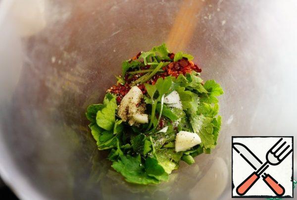 Put everything in layers in a blender bowl. A little greens, a little salt, a little garlic, a little black freshly ground pepper, a little red hot pepper. I prefer pepper flakes. You can also chop it. You can take fresh chili. I like spicy, so I put about 1 tsp of red pepper. You are guided by your own taste. You can first put a little, and then try and add if desired. After the first layer, again greens, salt, garlic, pepper. And so we fill the blender.
