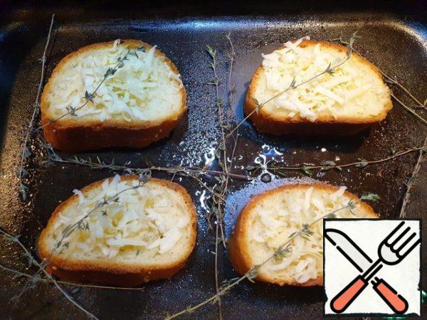 Slice the loaf, sprinkle with olive oil, sprinkle with grated cheese and warm up in the oven for 5 minutes.
