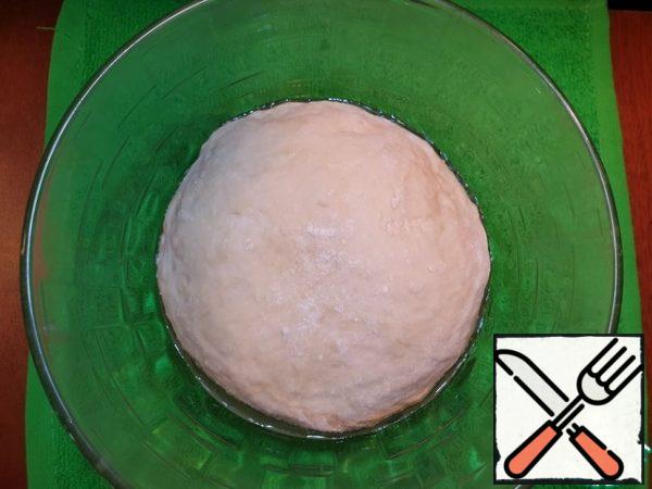 Knead the soft, not sticky to the hands of the dough. Roll into a ball, transfer to a greased container, cover and remove to a warm place for 40-60 minutes.