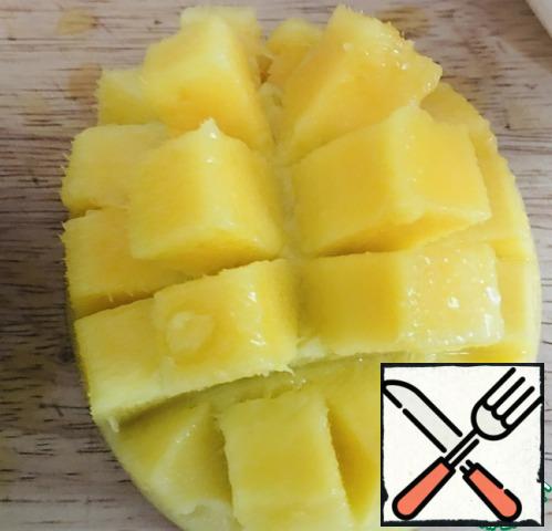 Take one half of the mango. cut into squares (it is so convenient to eat and cut squares into a bowl. With bottom a bit turn out in the upper hand together with skins.