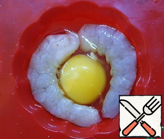 Into molds for baking, break eggs one by one. Add shrimp. Salt.
