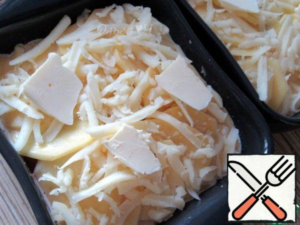 Sprinkle with the remaining grated cheese, add pieces of butter.