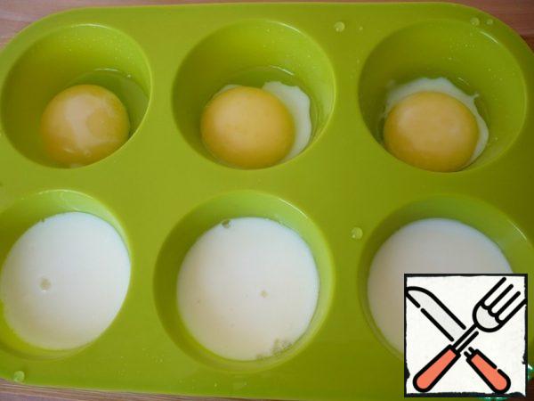 Meanwhile, the form with the ready eggs is taken out of the oven. The readiness of the protein can be checked by clicking on it with your finger.