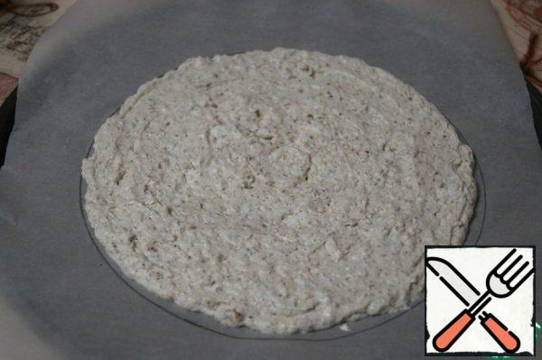 On a parchment sheet, draw a circle of the desired diameter. Protein-nut mass is transferred to a pastry bag and form a cake on greased with vegetable oil parchment. The mass should be divided into 2 cakes. Bake the cake at a temperature of 150 degrees for 20 minutes. Then the cake is not much cool and remove the parchment. The same is done with the second cake.