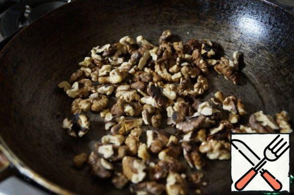 Walnuts fry in a pan, and then grind into not very fine crumbs.