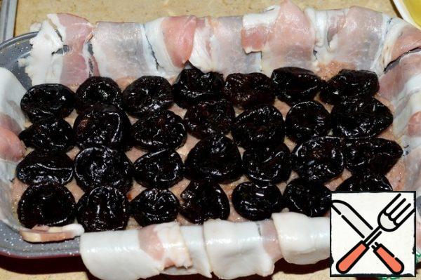 Put half of the minced chicken on the bacon, put the soaked prunes on top in an even layer.
