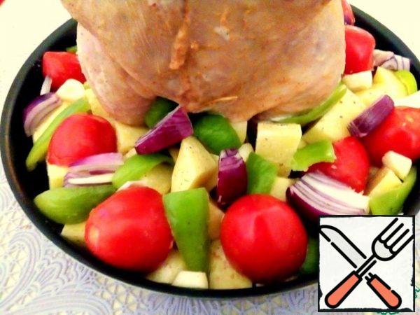 Put the potatoes around the chicken, add more vegetables: tomatoes cut in half, pepper strips, onion slices, garlic rings. You can take any vegetables that you have in the house.