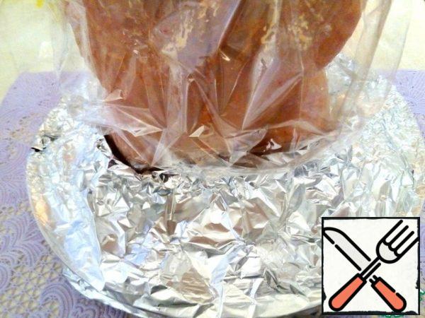 The whole structure needs to be covered. On the chicken, put on the cap from the package for baking, linking one edge, on the potatoes in a circle, put the foil.