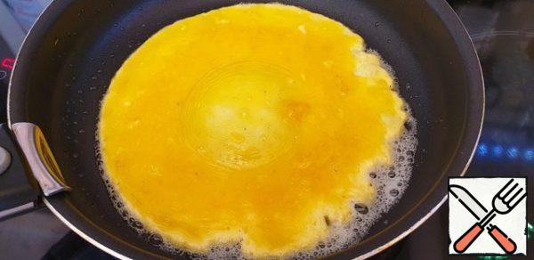 Heat the oil in a frying pan.
Pour in the egg yolks. The yolks should cover the entire bottom of the pan.
