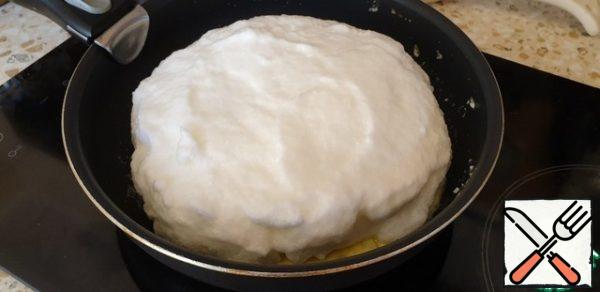 Using a spatula, evenly distribute the whites over the surface of the yolks.
Cover with a lid.
Fry on low heat for 5 minutes.
