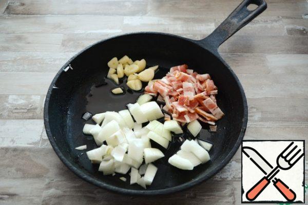 In vegetable oil, fry until transparent sliced onions, garlic and bacon