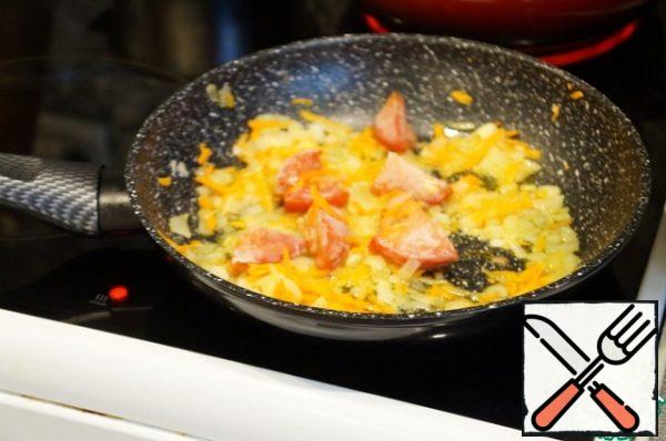 In the oil, lightly fry the onion, add the carrots and tomatoes, a little passerovat.