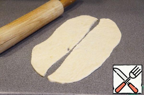 Now I'll show you the molding. Roll out a piece of dough into an oval or rectangle, cut in half.