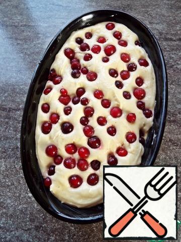 Lay out the remaining dough, smooth. Arrange the cranberries.
Slightly press the berries into the dough.