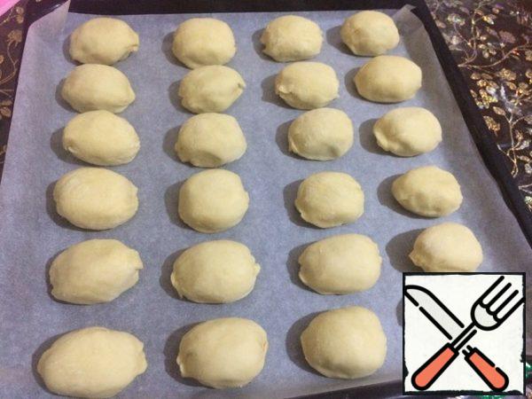 Then the edges of the patties carefully "collect". Spread our blanks on a baking sheet, covered with parchment paper. If desired, you can lubricate them by mixing one yolk and a tablespoon of milk, so they will turn out more ruddy.