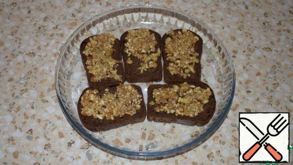 In a mortar, grind nuts, garlic, a pinch of salt and 3 tablespoons of olive oil into a paste.
Spread the nut paste evenly over the bread. Put the bread on a baking sheet and put it in preheated to 180 degrees. oven for 10 minutes . Let it cool down a little.
