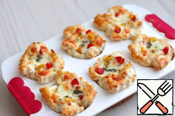Send the mold to a preheated 200 * c oven. Bake puff mini pizzas until golden brown.
