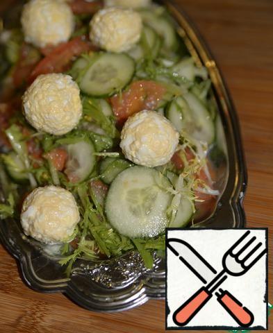 On a serving dish put the salad on top of the vegetables put cheese balls. 