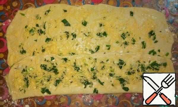 Fold the dough into the middle along with the filling.
Again grease with oil, sprinkle with flour, put the greens and cheese, without garlic.
