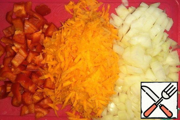 Onion and sweet pepper cut into cubes, carrots grate on a large grater.