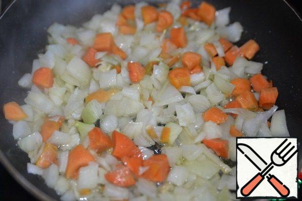 In a hot pan, pour vegetable oil and fry the carrots and onions over medium heat with the lid closed for 10 minutes.