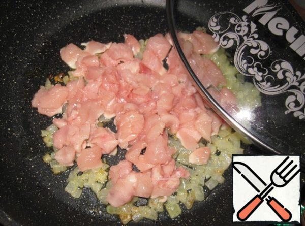 In a frying pan, heat the vegetable oil and saute the finely chopped onion in it over medium heat until translucent. Add the chicken meat, cut into small pieces. Fry until Golden brown, stirring occasionally.