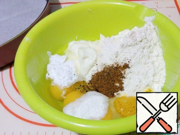 Prepare the form, cover with parchment, grease with oil, leave the silicone as it is.
Mix eggs, sour cream, mayonnaise, flour, starch, turmeric, baking powder, pepper mixture, salt.