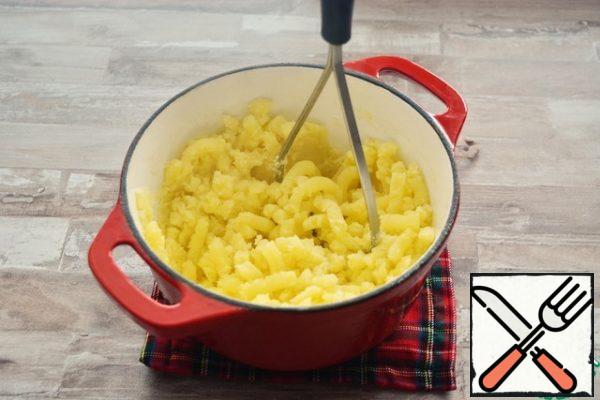 Potatoes should be cooked very well, even a little overcooked. Drain the broth, save it. Return the potatoes to the stove and lightly dry. Then mash the potato masher all the potatoes without liquid.