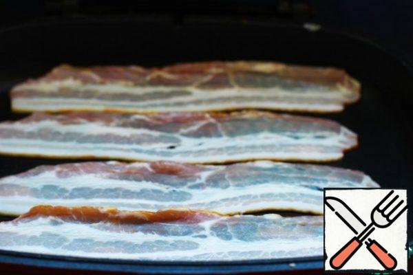 Wash the scallops. Put the strips of bacon in a dry frying pan and fry them to make a fragrant fat for scallops.
