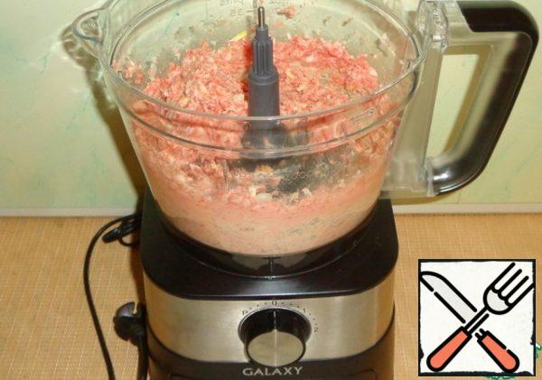 In the bowl of the food processor, insert the chopper knife, close the lid, turn the pork, onion and garlic into minced meat. We get a tender minced meat, which can immediately be used for cooking cutlets.